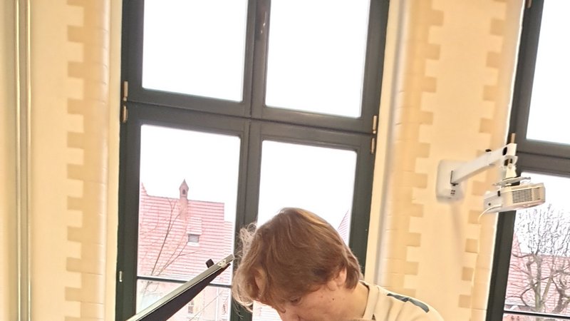 2 Personen an einer manuellen Druckpresse