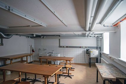 Blick in den Werkraum mit mehreren Gruppenwerkbänken